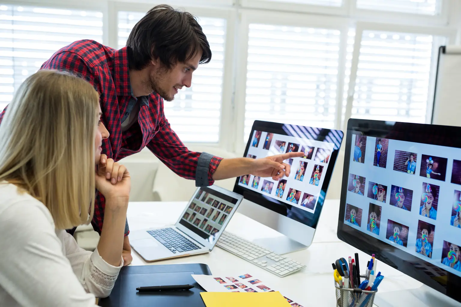 Equipo creativo seleccionando y editando imágenes en varios monitores para optimizar contenido visual